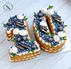 two cakes are decorated with blueberries and seashells