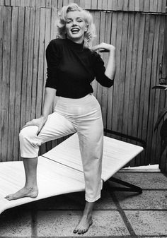 marilyn monroe posing on top of a surfboard