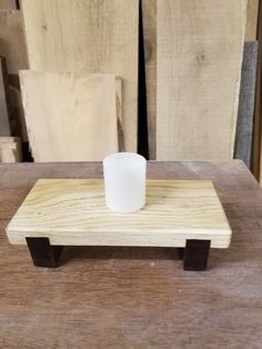 a small wooden tray with a white cup on it sitting on top of a table