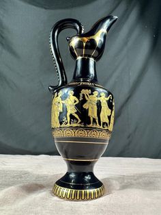 a black and gold vase sitting on top of a table