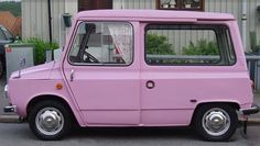 a pink car is parked on the side of the road