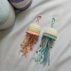 two crocheted jellyfish ornaments sitting on top of a bed