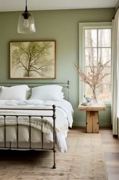 a bedroom with green walls, white bedding and an antique style iron bed frame