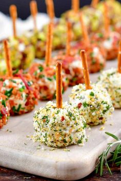 small appetizers are lined up on a cutting board with toothpicks sticking out of them