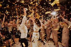 a group of people standing on top of a dance floor surrounded by confetti