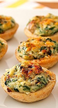 mini quiches filled with spinach and cheese on a white plate, ready to be eaten