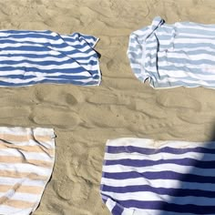 four beach towels laid out on the sand