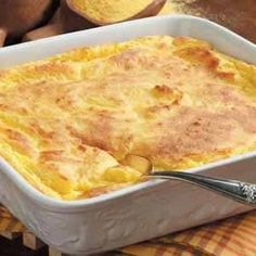 a casserole dish with cheese and bread on the side, ready to be eaten