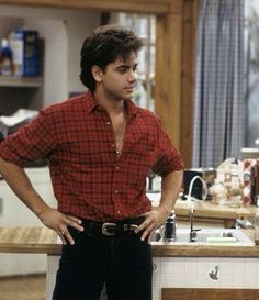 a man standing in front of a kitchen counter with his hands on his hips while looking at the camera