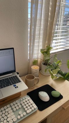 a laptop computer sitting on top of a wooden desk next to a keyboard and mouse pad