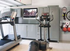 an exercise room with treadmills and television