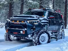 a truck is driving through the snow in the woods