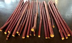 several red sticks are lined up on a wooden table with some yellow pins sticking out of them