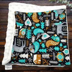 a black and white blanket with colorful animals on it