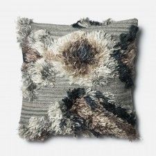 a gray and black pillow with fringes on the front, sitting on a white surface