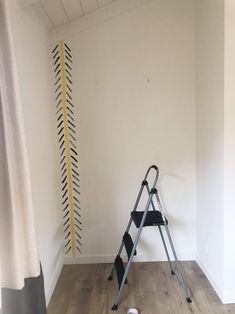 a ladder leaning against a wall next to a window with an arrow drawn on it