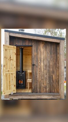 a wood burning stove inside of a wooden shed with doors open to reveal the outside