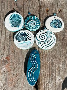 four ceramic plates with designs on them sitting on a wooden table next to each other