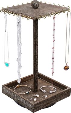 a wooden jewelry stand with various necklaces and bracelets hanging from it's sides