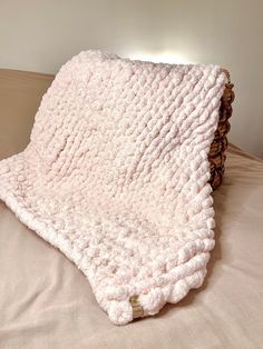 a white blanket sitting on top of a bed