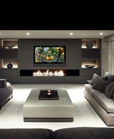 a large living room with couches and a flat screen tv mounted on the wall