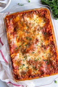 a casserole dish with meat and cheese in it on a red and white towel