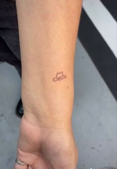 a small hat tattoo on the ankle