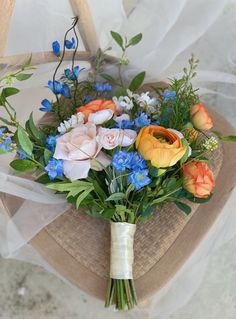 a bouquet of flowers sitting on top of a wooden chair