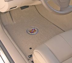 the interior of a car with an emblem on the floor and steering wheel in it