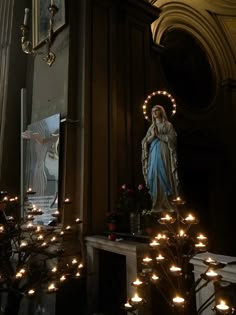 the statue of mary is surrounded by candles