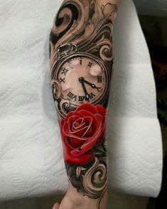 a person with a tattoo on their arm holding a clock and a rose in it