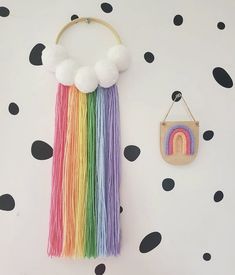 there is a wall hanging with a rainbow decoration on it and a small purse next to it