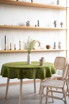 there is a table with a green table cloth on it and two chairs in front of the table