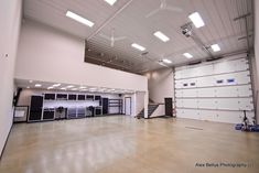 large garage organization tips with white walls and overhead lighting in an empty space that is being used for storage