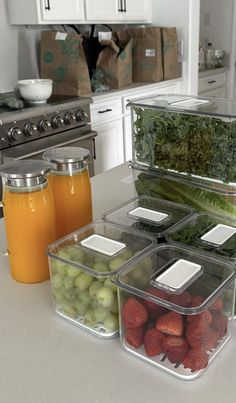 several containers filled with fruits and vegetables on a kitchen counter