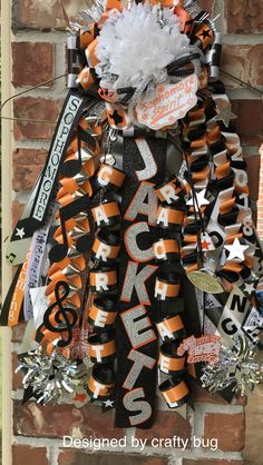 the front door is decorated with orange, black and silver ribbons that spell out rock city