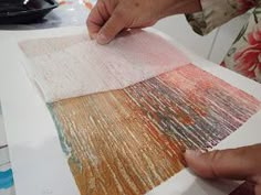 a person is working on an art project with colored paper and watercolor pencils