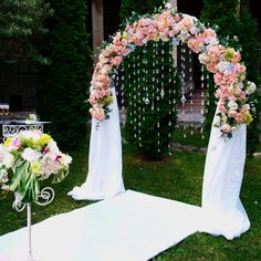 a wedding arch decorated with pink and white flowers