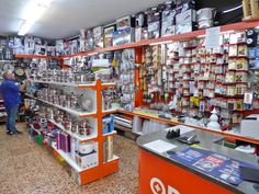 a store filled with lots of items and people standing in front of the shelves full of products