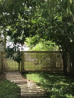 the back yard is fenced off with wood planks and grass on both sides