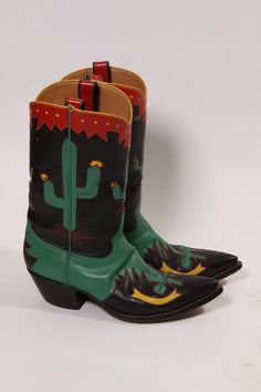 1990s Black, Green, Red and Yellow Novelty Cactus Handmade Custom Western Cowboy Boots These boots feature: *Black base color *Green, red and yellow accents *Custom and handmade *Feature inlay cactus and western details  *Leather material  *Has red leather boot loops  Label: Rocketbuster Boots Size: Labeled men's size 9  Measurements: Length: 11" Width: 3 7/8" Heel Height: 2" Vamp: 5 5/8" Boot Height: 13" Condition: Excellent. Some wear to the sole consistent with age and wear. *Shoe size is bas Rocketbuster Boots, Custom Cowboy Boots, Red Leather Boots, Boot Design, Mens Cowboy, Yellow Accents, Cowboy Western, Cowboy Boot, Leather Boot