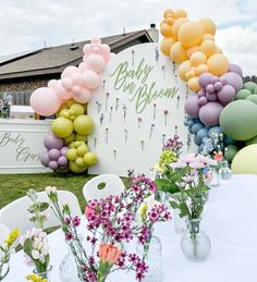 there are many flowers and balloons on the table