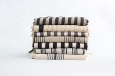 four towels stacked on top of each other in black and white striped patterns, with one folded