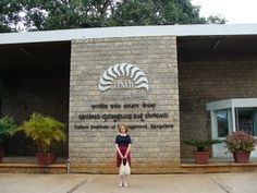 a woman standing in front of a building with a sign that says time on it