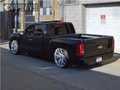 a black truck parked in front of a garage