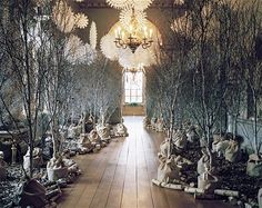 a room filled with statues and chandeliers hanging from the ceiling