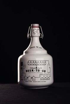 a white jug with a drawing on it sitting on top of a wooden table in front of a black background