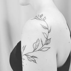 a woman with a tattoo on her shoulder has leaves growing out of the back of her shoulder