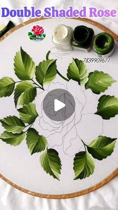 an embroidery project with green leaves on it