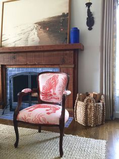 a chair sitting in front of a fire place next to a painting on the wall